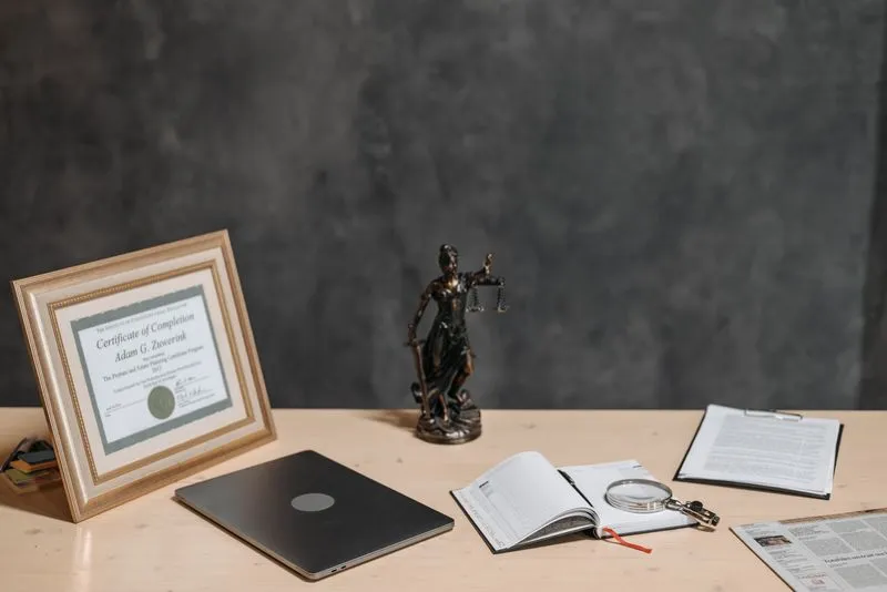 A certificate beside a laptop on a desk
