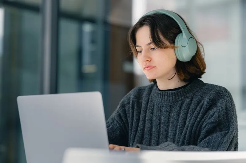Person learning online at a laptop with headphones
