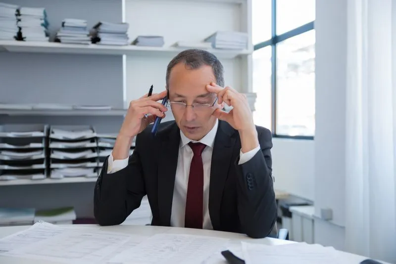 Busy business owner managing multiple tasks at a desk