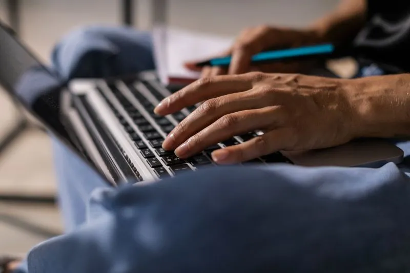 Writer typing a content draft on a laptop screen