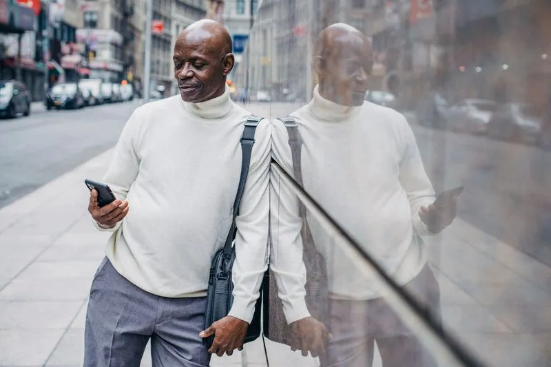 Person searching on a smartphone in a Nigerian street market